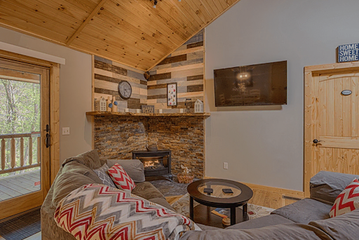 Living area with TV and fireplace in Mountain Creek Cabin in Maggie Valley, NC